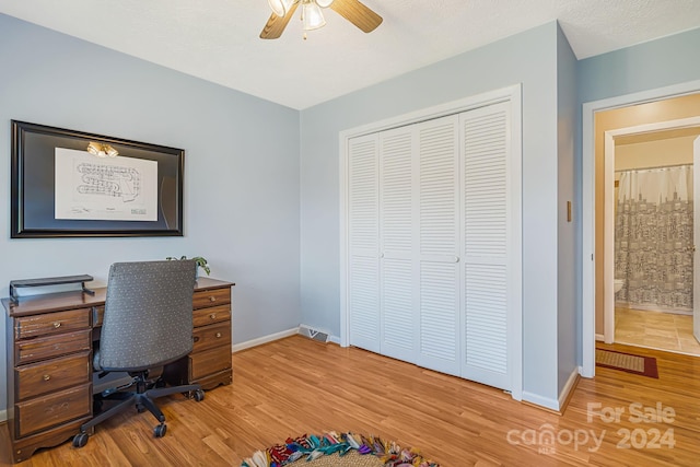 home office with ceiling fan, a textured ceiling, and hardwood / wood-style flooring