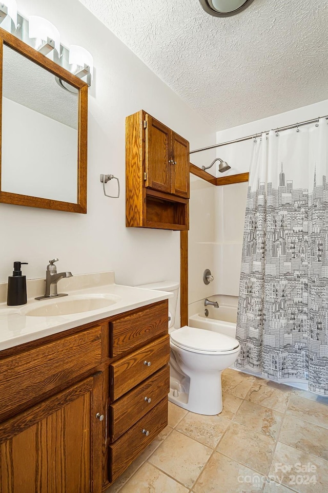 full bathroom with vanity, toilet, shower / bath combo with shower curtain, and a textured ceiling