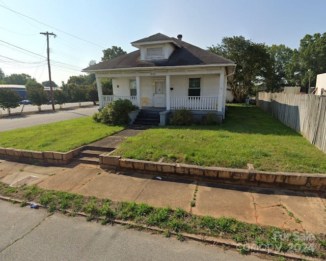 bungalow-style house with a front lawn and covered porch