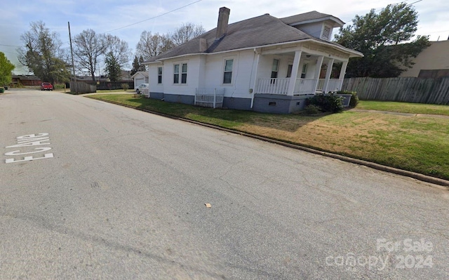 view of front of house with covered porch and a front lawn