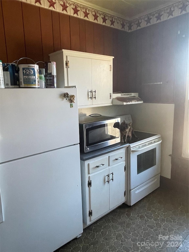 kitchen featuring stove, ventilation hood, dark tile patterned flooring, white cabinets, and white fridge