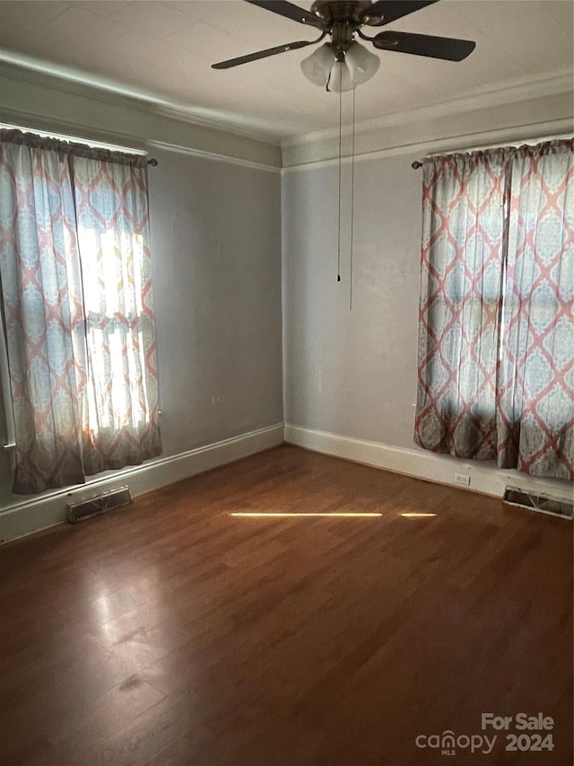 empty room with ceiling fan, wood-type flooring, and ornamental molding