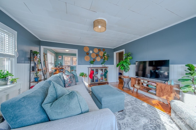 living room featuring hardwood / wood-style floors, crown molding, and wooden walls