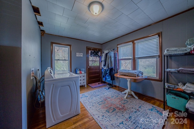 bedroom with light hardwood / wood-style floors, crown molding, and washing machine and clothes dryer