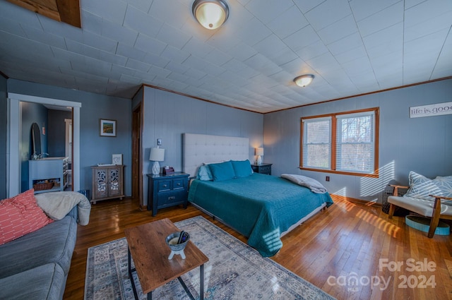 bedroom with crown molding and dark hardwood / wood-style flooring