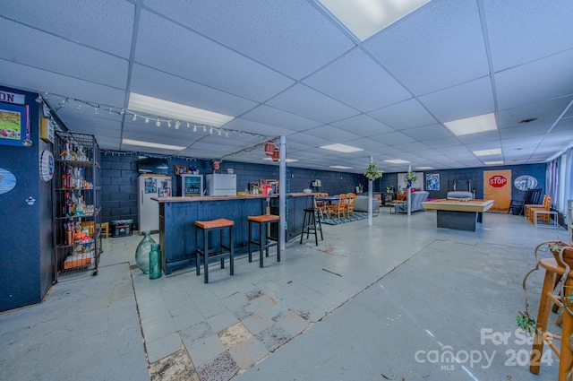 bar with a paneled ceiling and white fridge