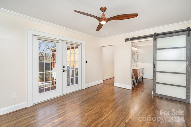 interior space featuring french doors, ceiling fan, crown molding, a barn door, and dark hardwood / wood-style floors