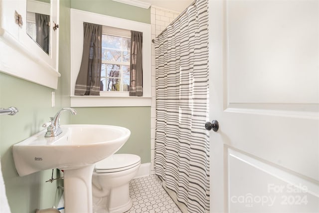 bathroom with toilet, a shower with curtain, and tile patterned floors