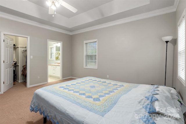 carpeted bedroom featuring a tray ceiling, ceiling fan, a spacious closet, connected bathroom, and a closet