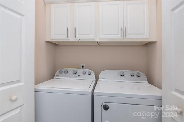 washroom with washer and clothes dryer and cabinets