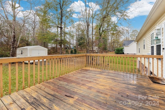 wooden terrace with a storage shed and a yard