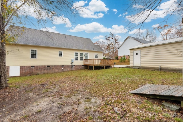 back of house with a deck and a lawn