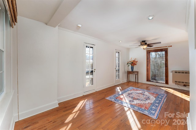 foyer entrance with hardwood / wood-style floors, ceiling fan, ornamental molding, beamed ceiling, and radiator heating unit