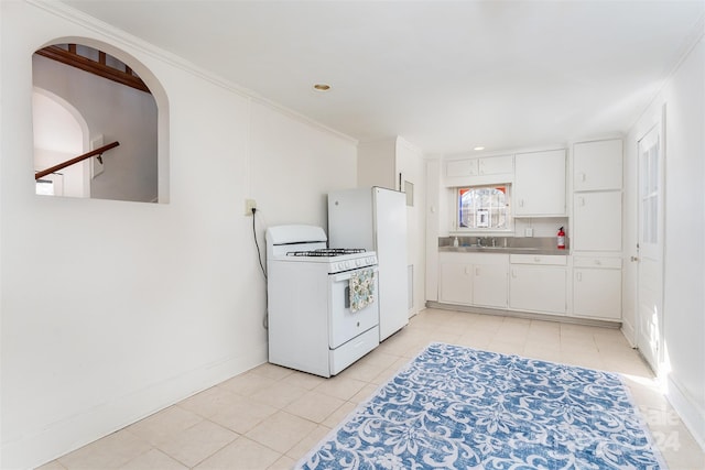 kitchen with sink, light tile patterned flooring, white appliances, white cabinets, and ornamental molding