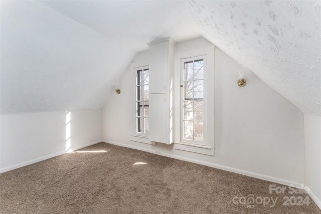 bonus room with carpet floors and vaulted ceiling