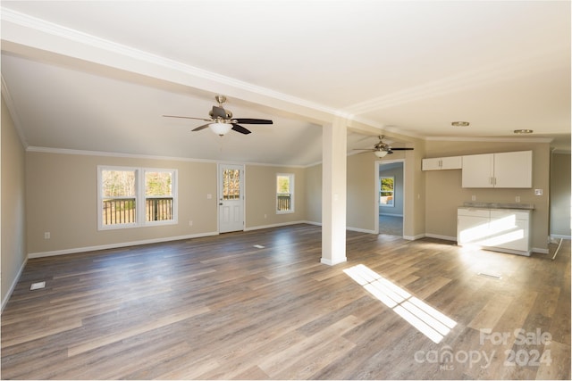 unfurnished living room featuring hardwood / wood-style floors, ceiling fan, and crown molding