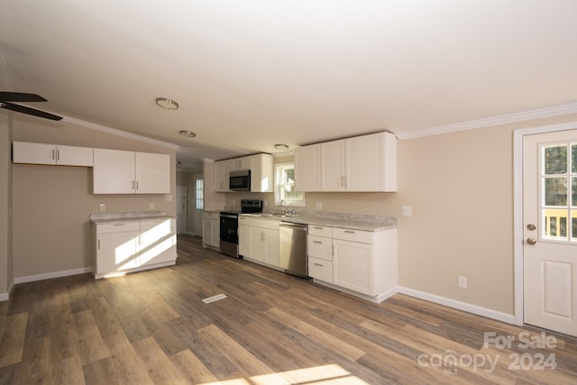 kitchen with white cabinets, sink, stainless steel appliances, and hardwood / wood-style flooring