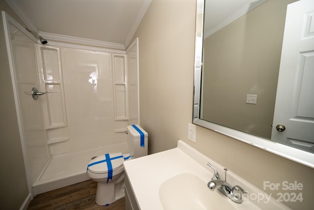 bathroom featuring a shower, hardwood / wood-style floors, toilet, and crown molding