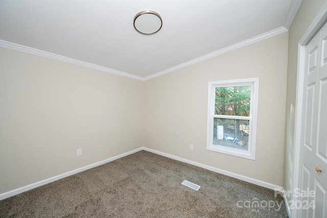 empty room featuring carpet floors, vaulted ceiling, and ornamental molding