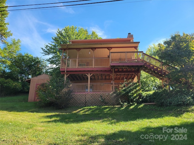 back of property with a storage unit, a deck, and a yard