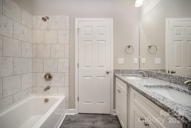 bathroom featuring vanity, tiled shower / bath combo, and hardwood / wood-style flooring