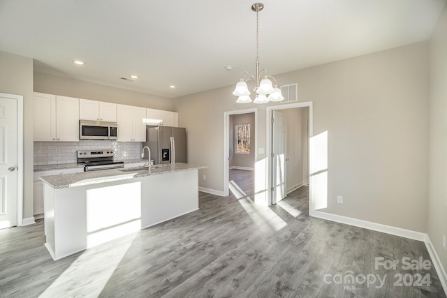 kitchen featuring white cabinetry, a center island with sink, stainless steel appliances, and light hardwood / wood-style floors