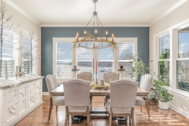 dining area with crown molding, wood-type flooring, and an inviting chandelier