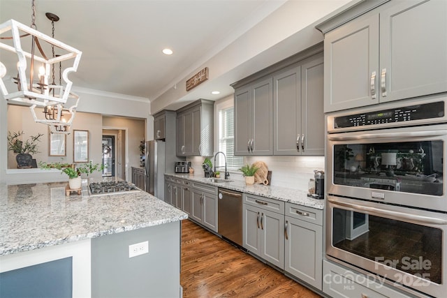 kitchen featuring pendant lighting, stainless steel appliances, sink, and gray cabinetry