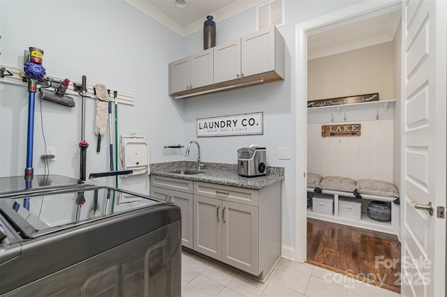 kitchen featuring sink, crown molding, gray cabinets, light tile patterned flooring, and separate washer and dryer