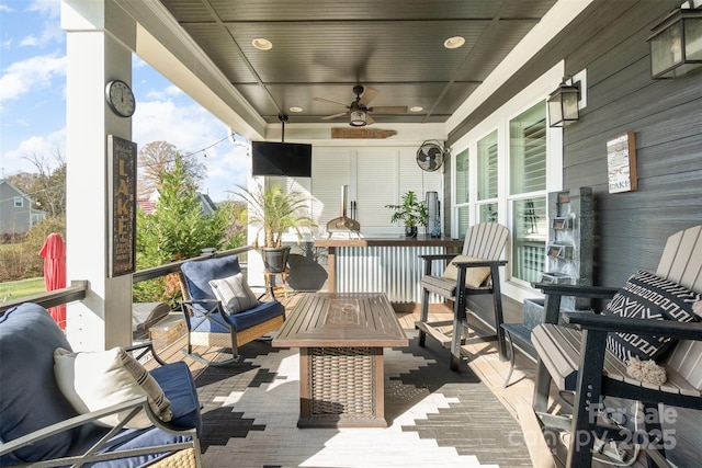 wooden terrace with an outdoor hangout area and ceiling fan