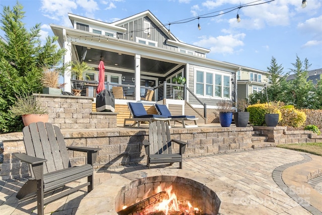 view of patio with a balcony and an outdoor fire pit