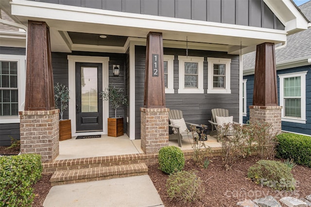 doorway to property featuring board and batten siding and covered porch