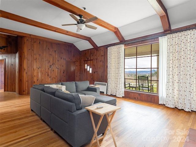 living room with vaulted ceiling with beams, wood walls, radiator heating unit, and wood-type flooring