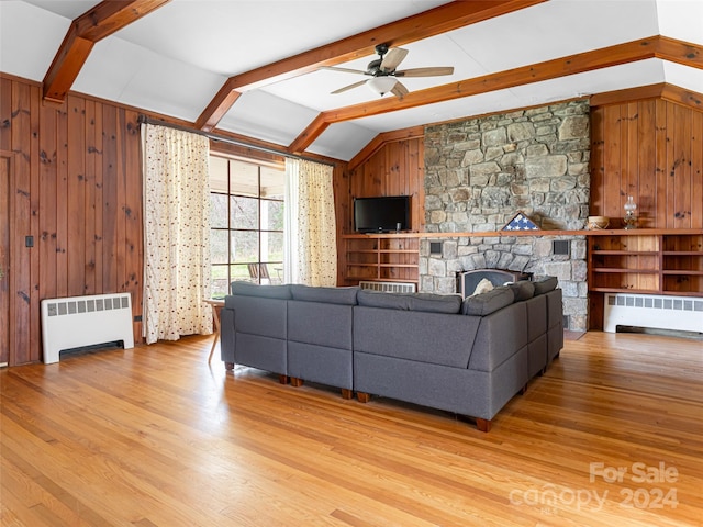 living room with vaulted ceiling with beams, light wood-type flooring, radiator heating unit, and wooden walls