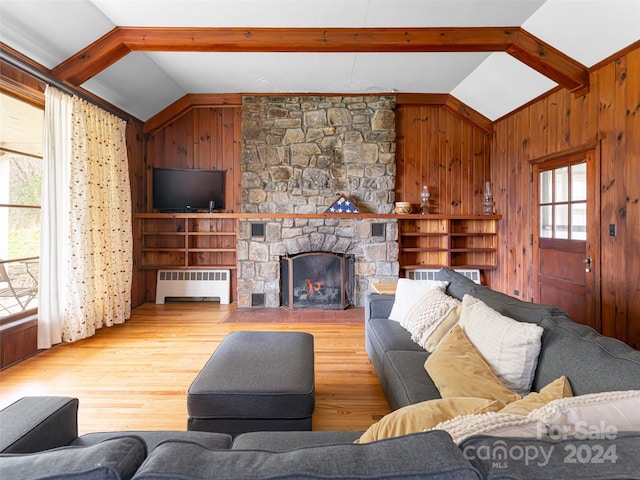 living room featuring a fireplace, lofted ceiling with beams, radiator, and a healthy amount of sunlight