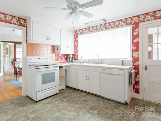 kitchen with white appliances, white cabinetry, plenty of natural light, and sink