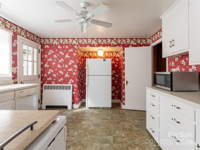 kitchen with white cabinets, radiator heating unit, white appliances, and ceiling fan