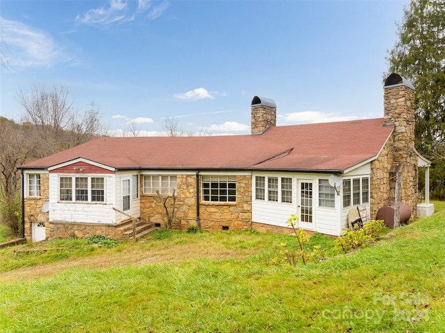 rear view of property featuring a lawn