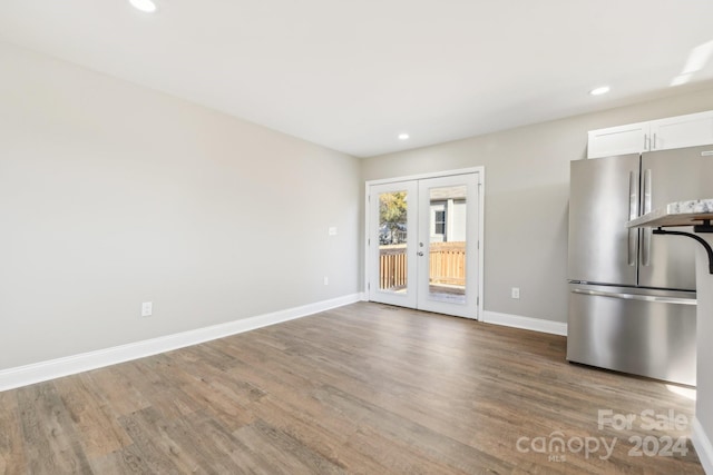 kitchen featuring stainless steel fridge, french doors, white cabinets, and hardwood / wood-style floors