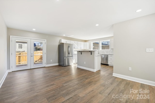 unfurnished living room with dark hardwood / wood-style floors and french doors