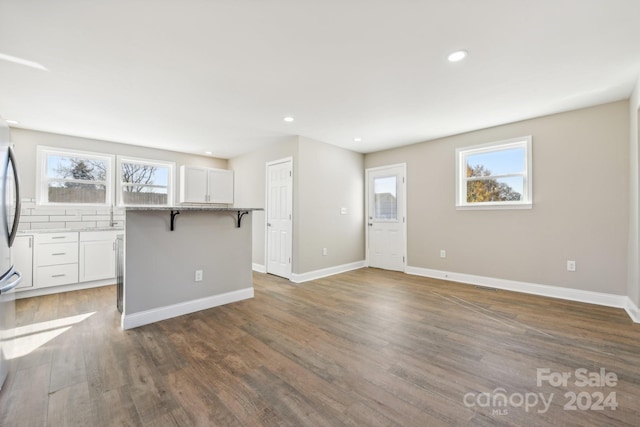 unfurnished living room with plenty of natural light, dark hardwood / wood-style flooring, and sink