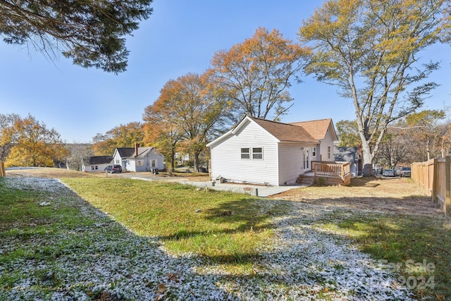 view of side of home with a lawn and a wooden deck