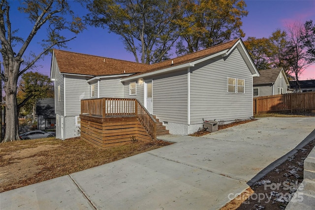 rear view of house with crawl space, a patio, roof with shingles, and fence