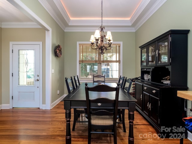 dining room featuring a notable chandelier, light wood-type flooring, and ornamental molding