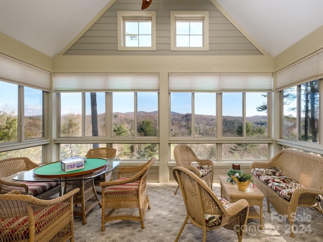 sunroom / solarium featuring a mountain view and lofted ceiling