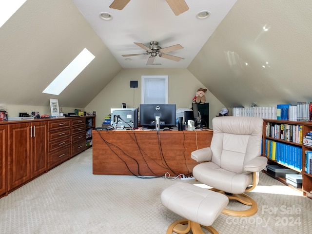 home office featuring ceiling fan, light colored carpet, and lofted ceiling with skylight