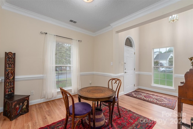 dining space featuring crown molding, hardwood / wood-style floors, and a textured ceiling