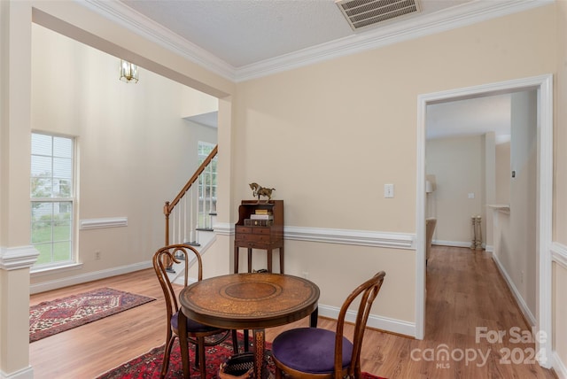 dining area featuring light hardwood / wood-style floors and ornamental molding