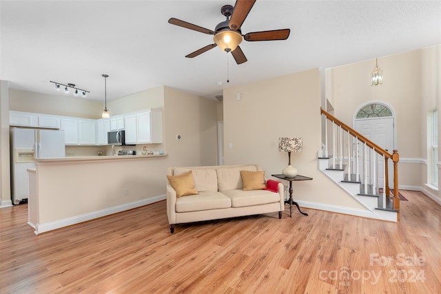 living room featuring ceiling fan, rail lighting, and light wood-type flooring