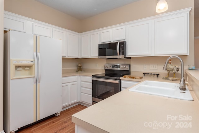 kitchen featuring sink, white cabinetry, stainless steel appliances, and light hardwood / wood-style flooring